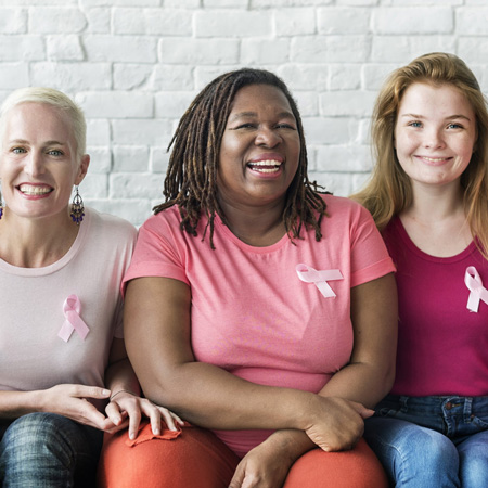 Women in pink shirts with pink ribbon pins